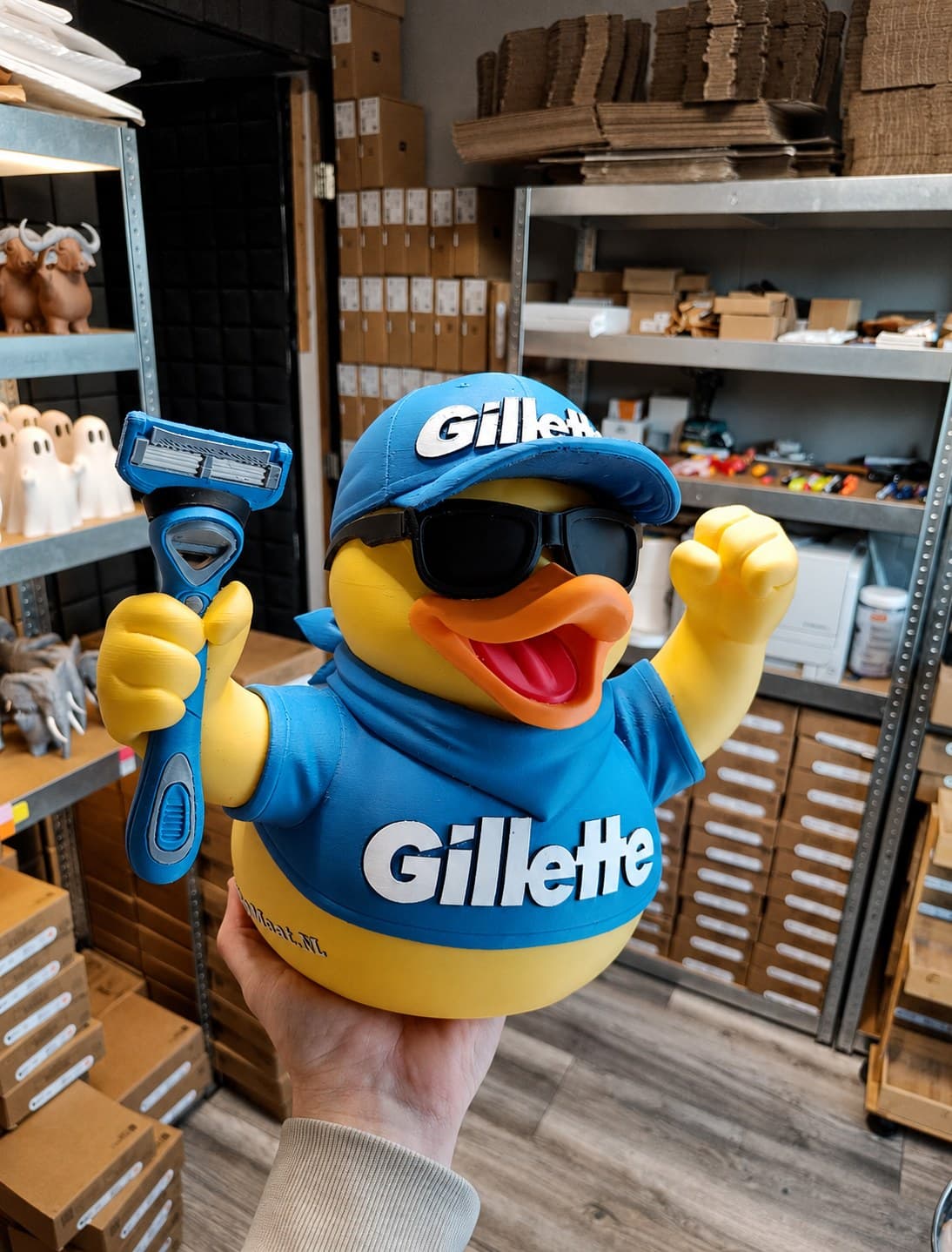 3D-geprinte Gillette-mascotte met pet, zonnebril en scheermes, in onze werkplaats