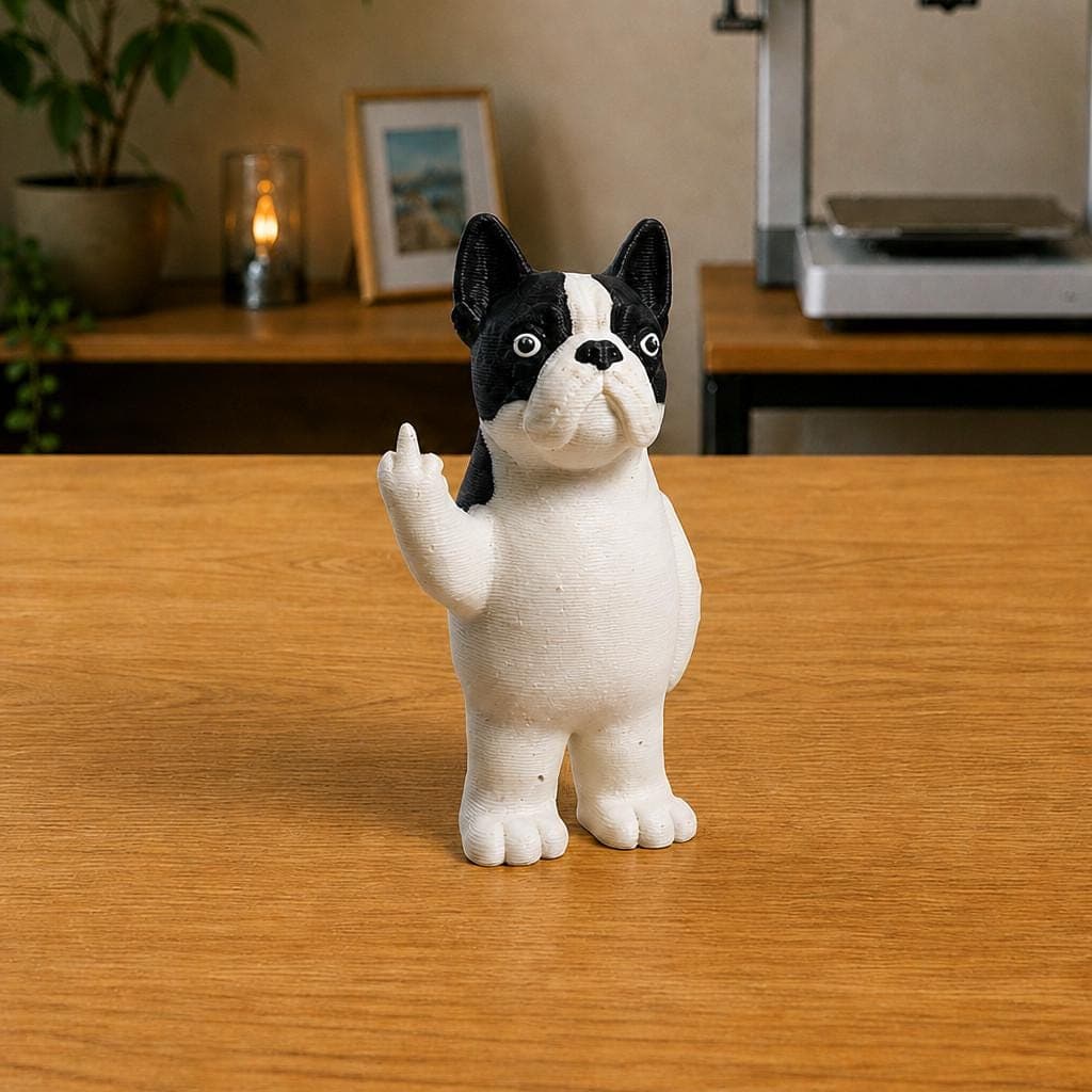 Funny black and white Boston Terrier figurine with upright ears and a short muzzle, shown from the front making a raised middle-finger gesture.