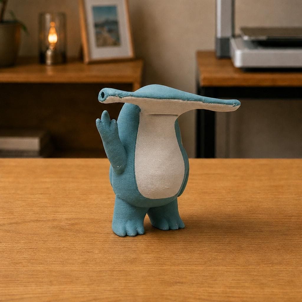 Funny blue hammerhead shark figurine with a wide flat head and white belly, shown from the front making a raised middle-finger gesture.
